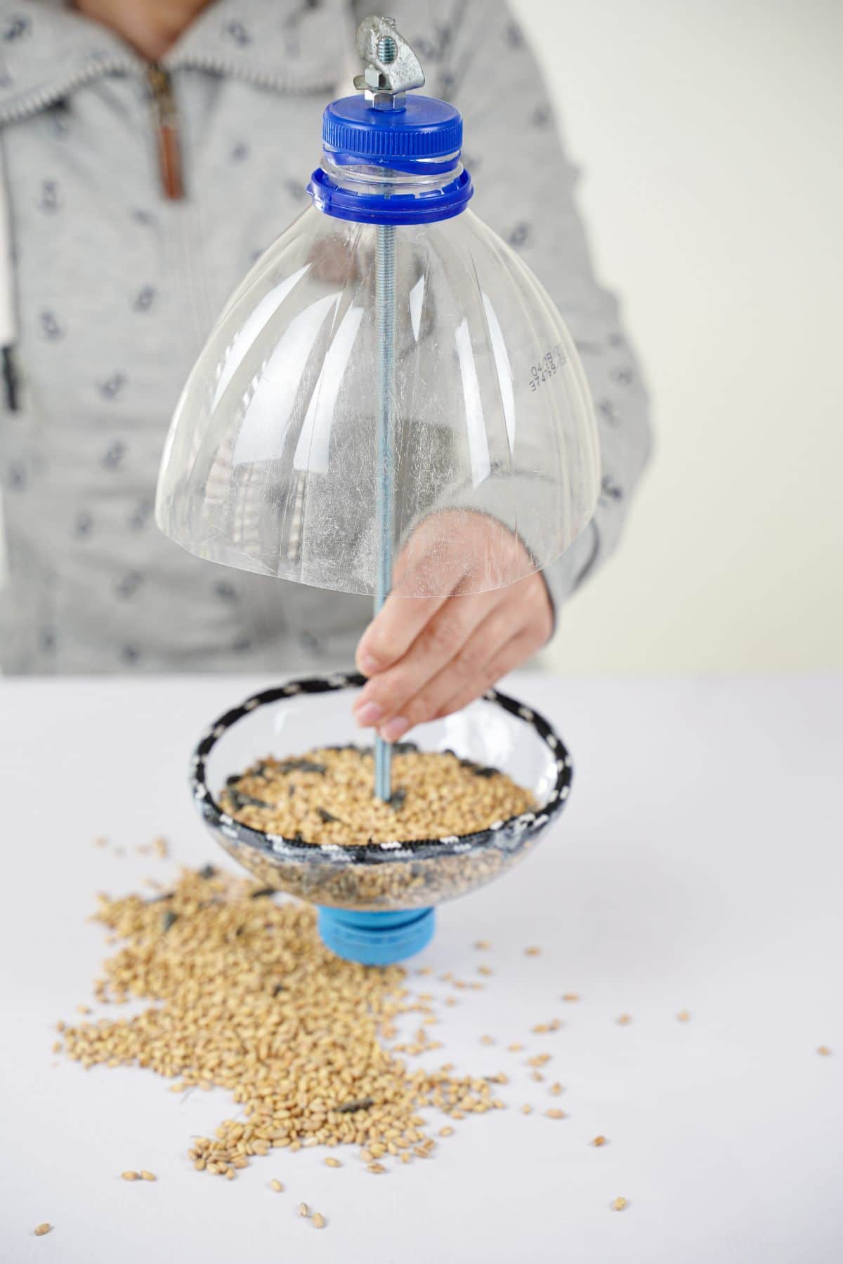woman filling bird feeder with seed