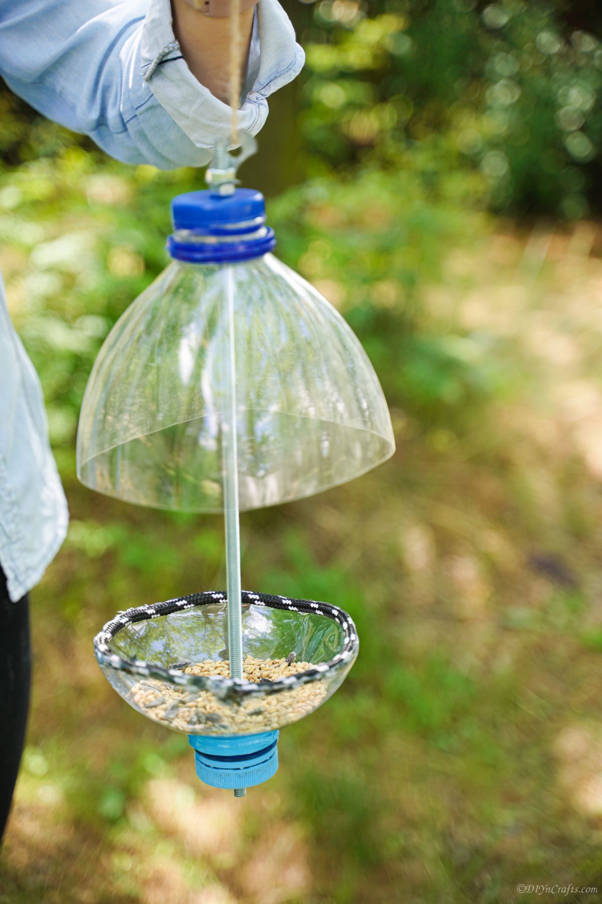 plastic bottle bird feeder being held by woman
