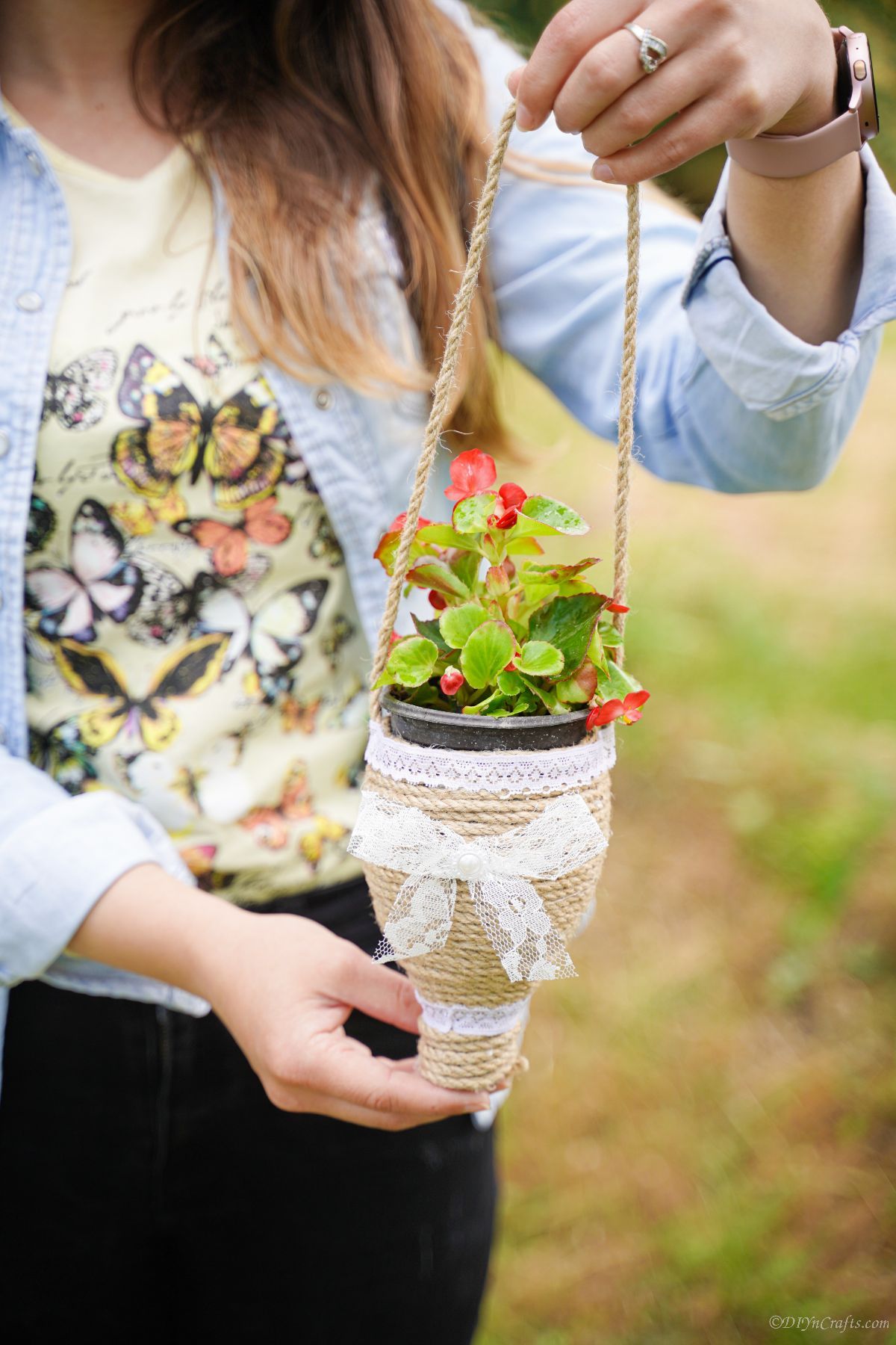 red flowers in twine planter held by woman