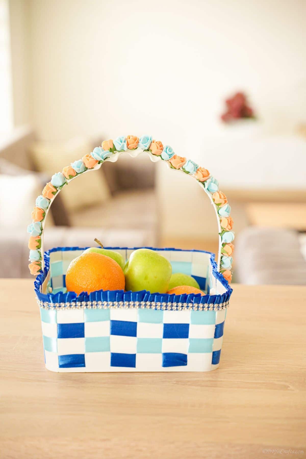 white and blue ribbon basket with fruit on table