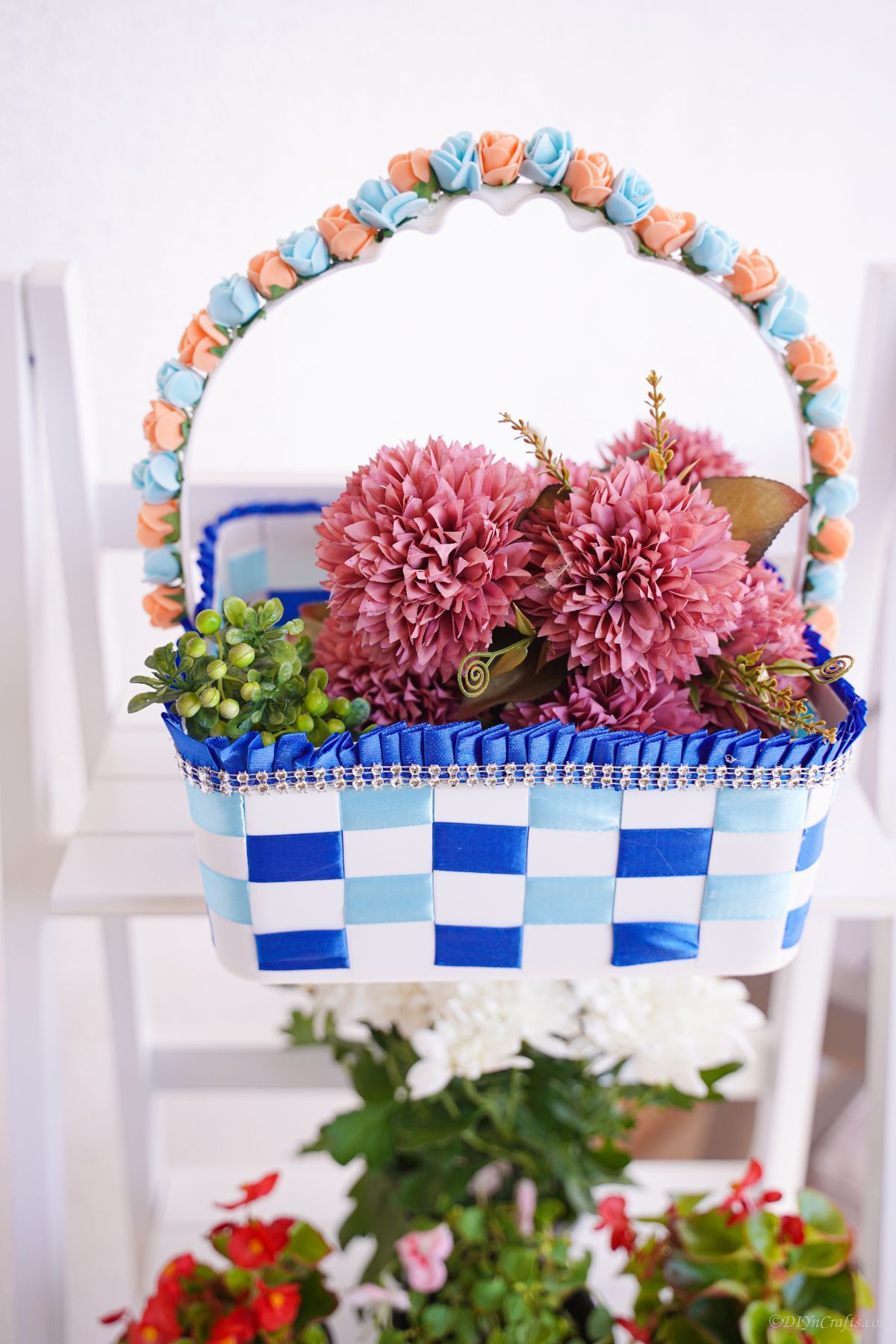 blue and white basket of pink flowers on white shelf