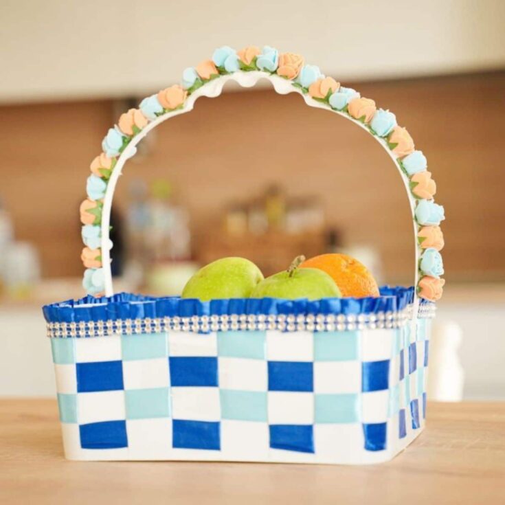 blue and white plastic basket on table with flowers on handle