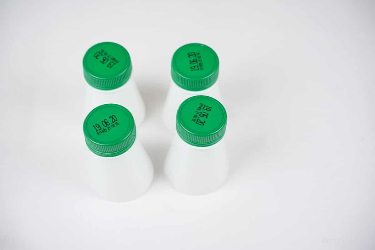 four bottle tops with green lids