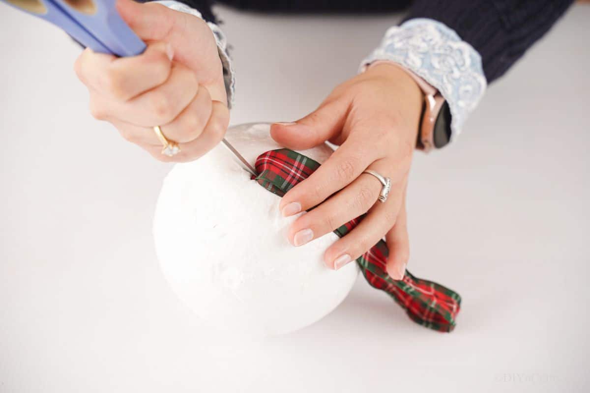 use the end of scissor to poke the end of the ribbon into the top of a styrofoam ball