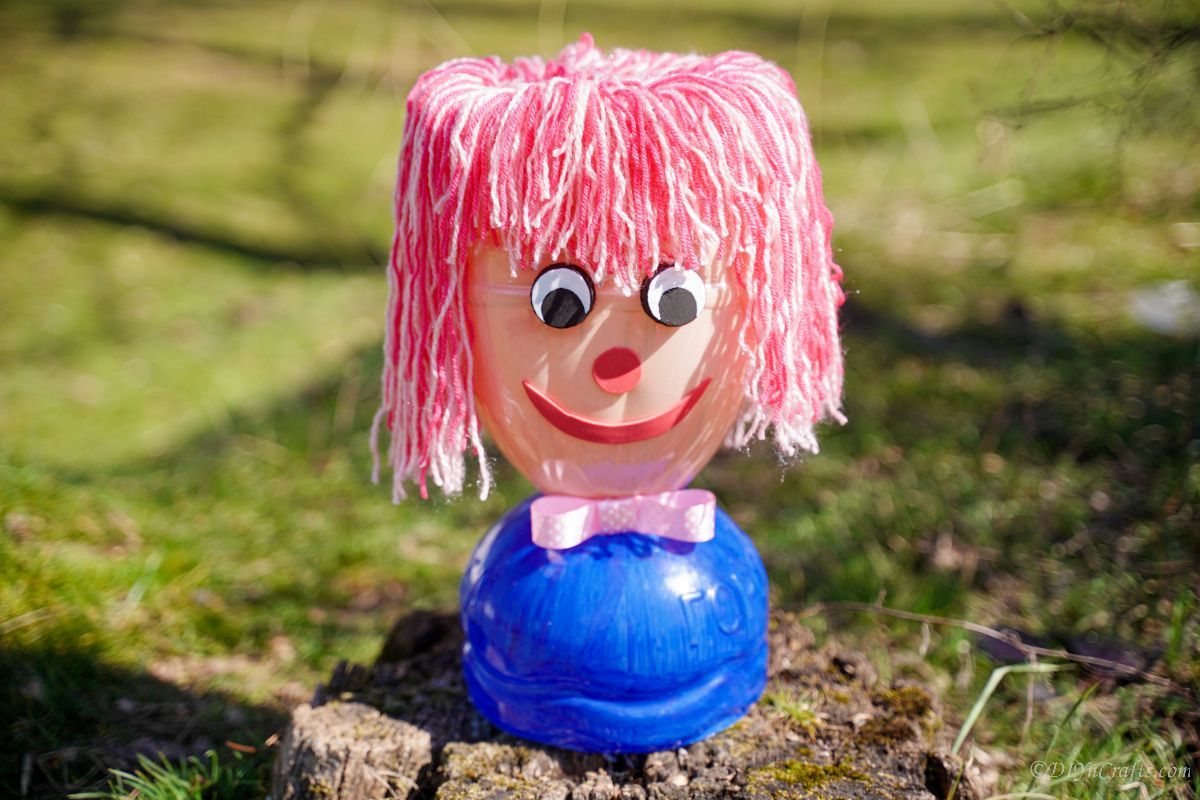 plastic bottle doll head on stump