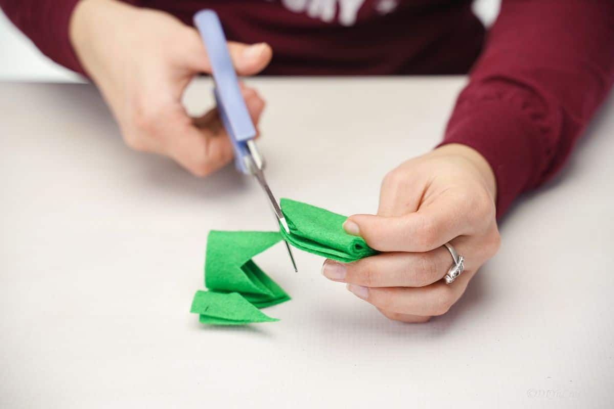 blue scissors cutting green felt