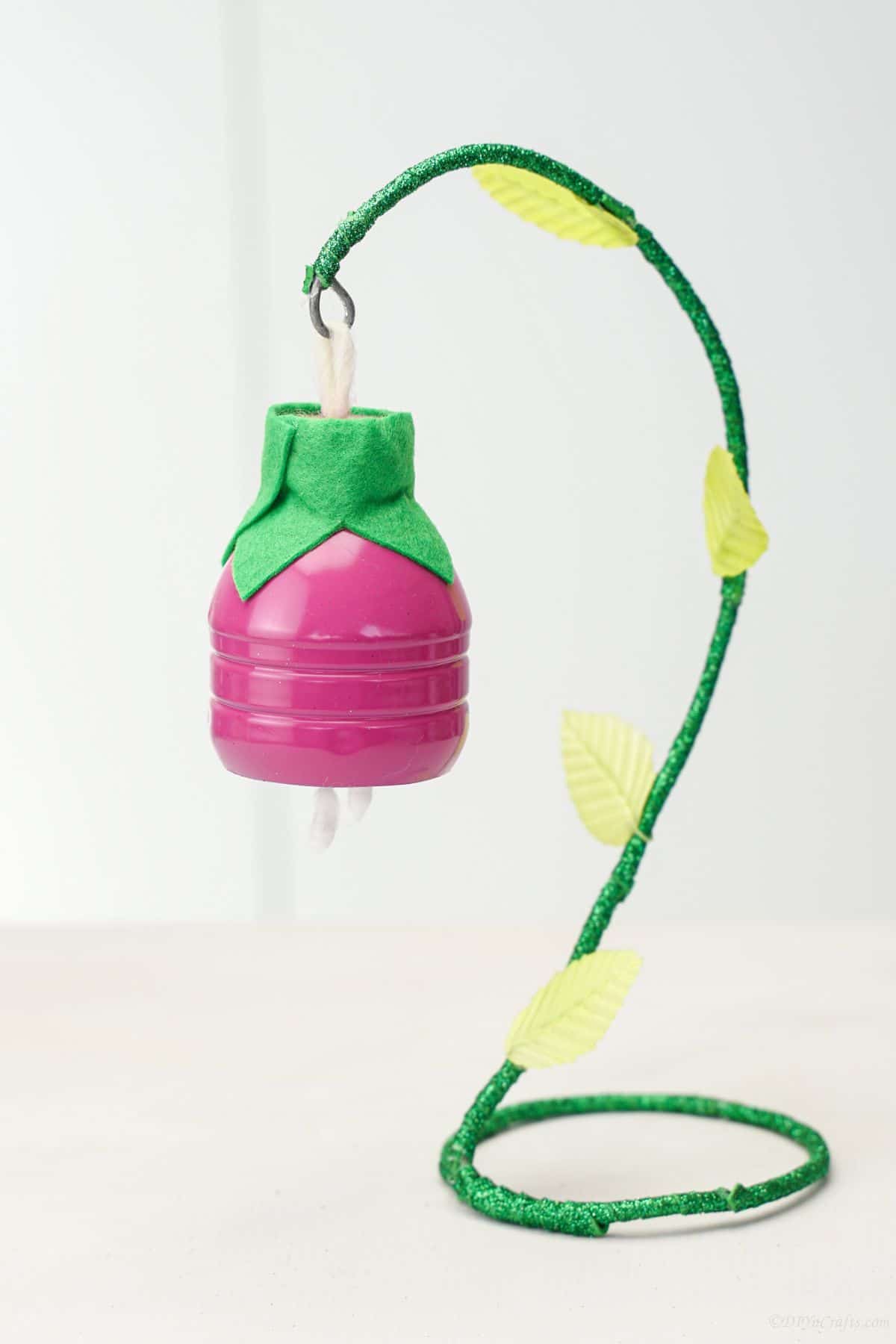 pink plastic bottle flower on green hook