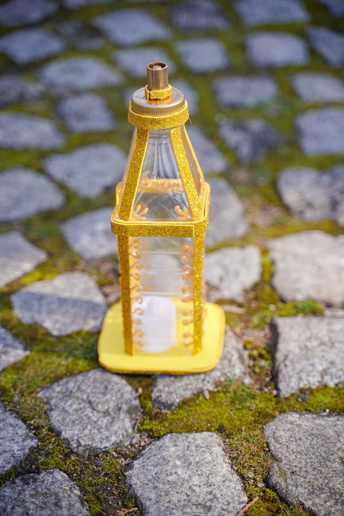 mini gold lantern on cobblestone