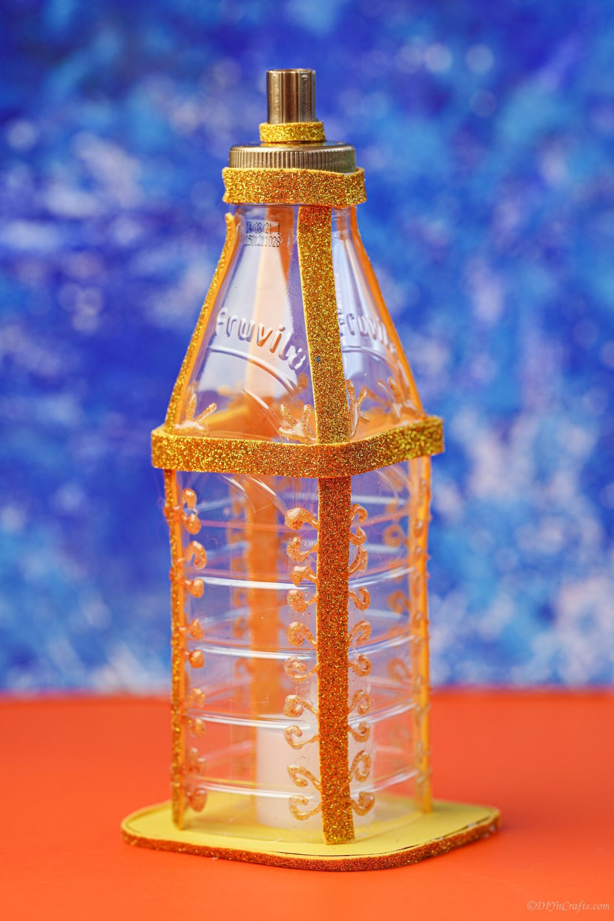 gold fake lantern on orange table with blue background