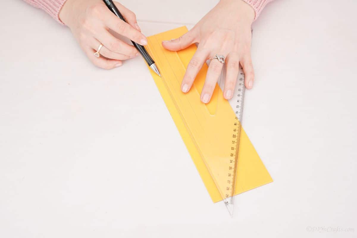 ruler and pen making measurements on yellow paper