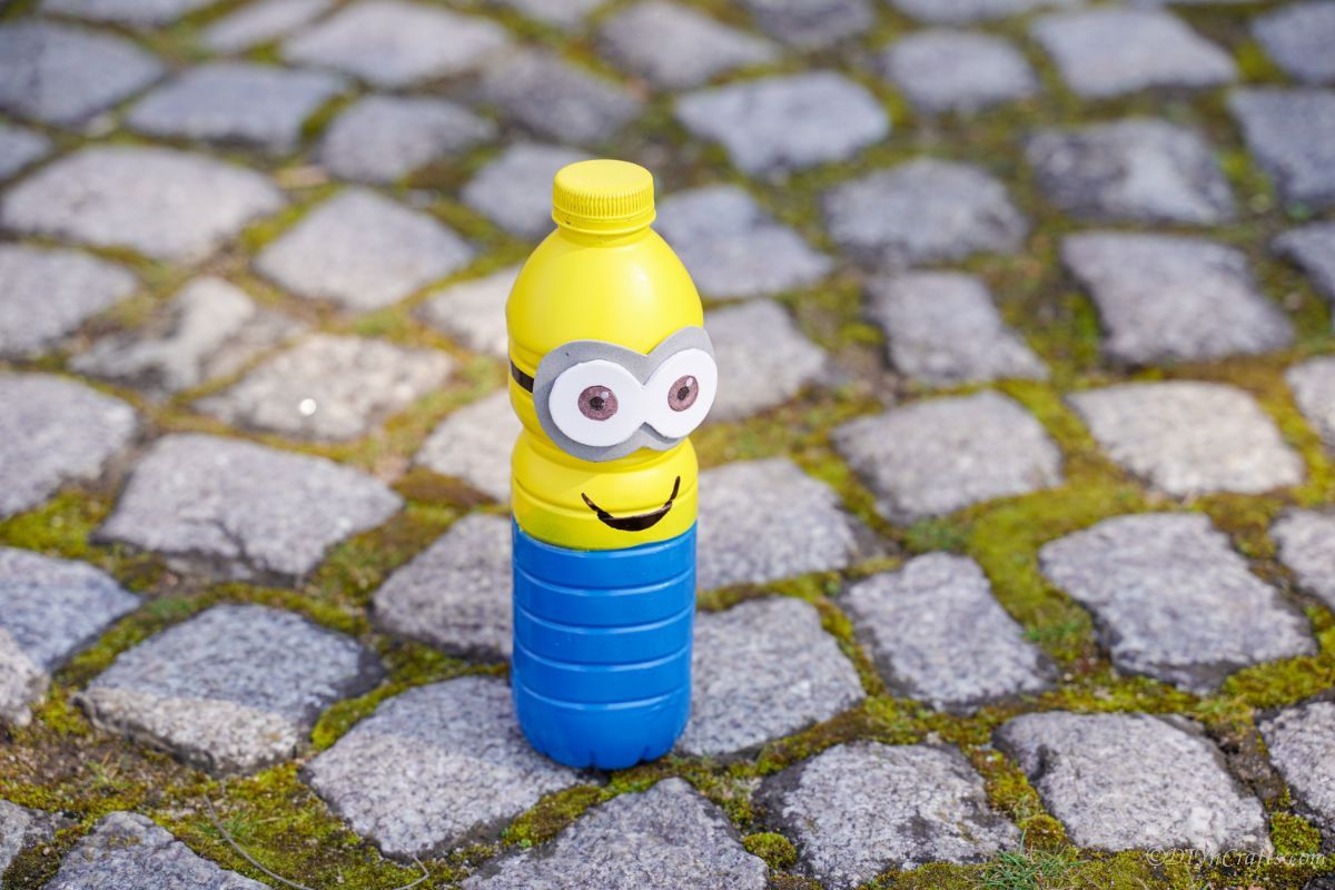 view looking down on plastic bottle minion on cobblestone path