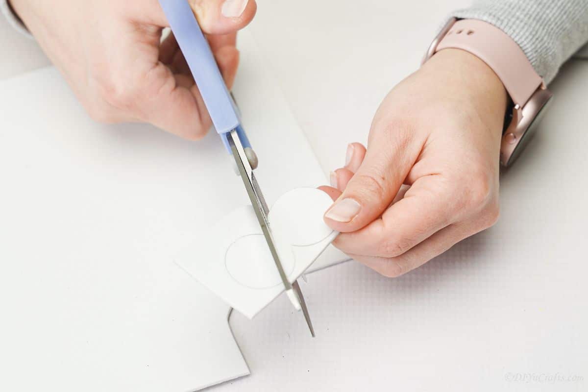 blue scissors cutting white foam paper