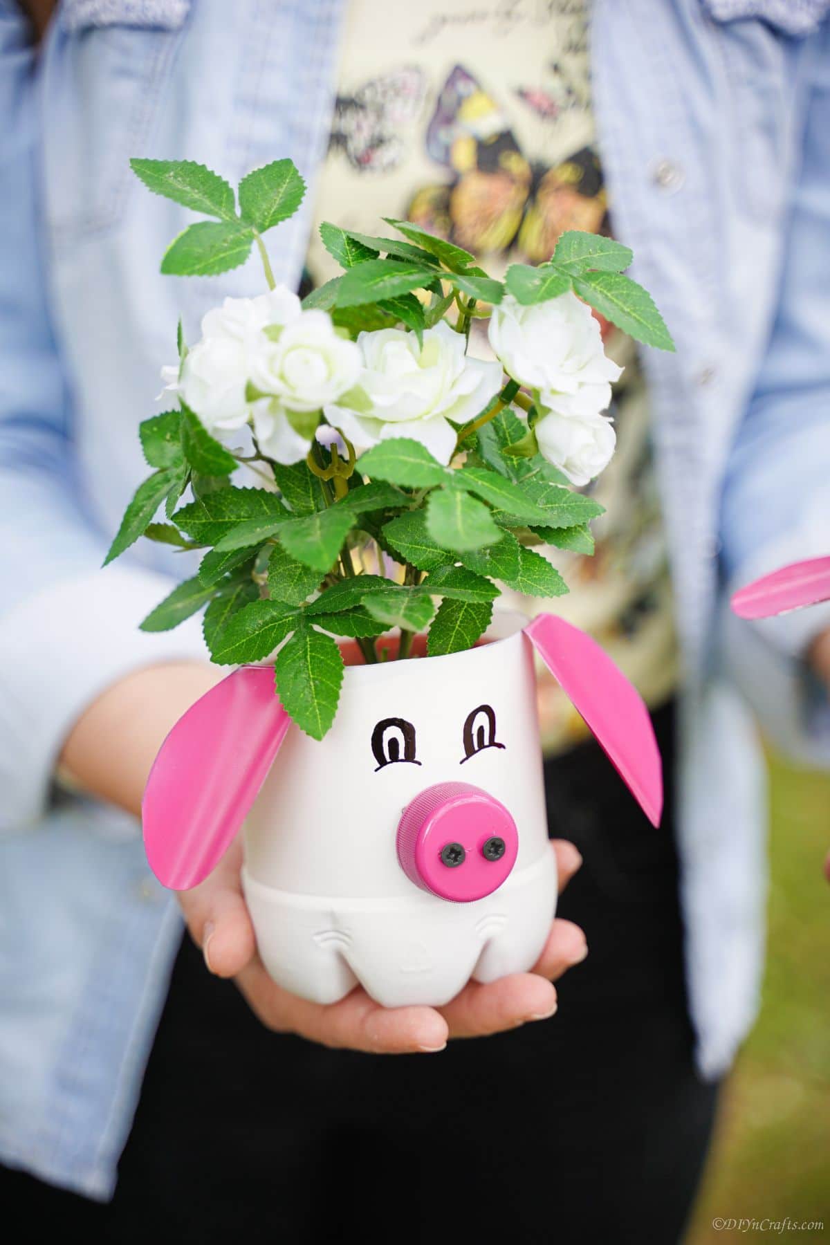 woman holding plastic bottle pig planter in her hand