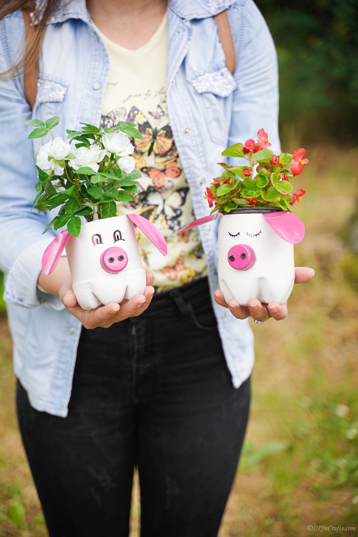 woman in blue shirt holding two pig planters