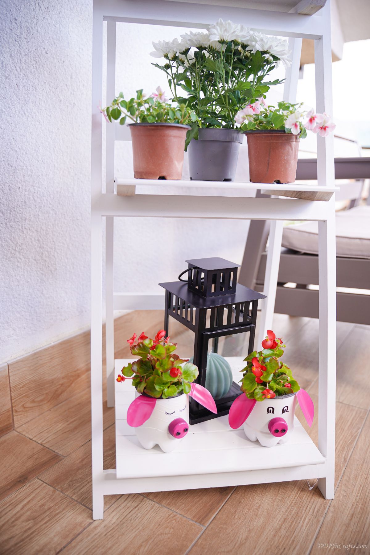 white corner shelf of flower pots with pig planters on base