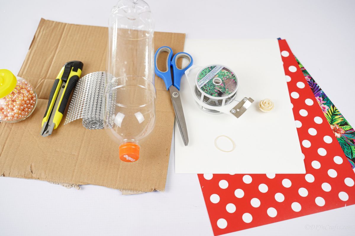 cardboard, paper, empty bottles, and craft supplies on white table