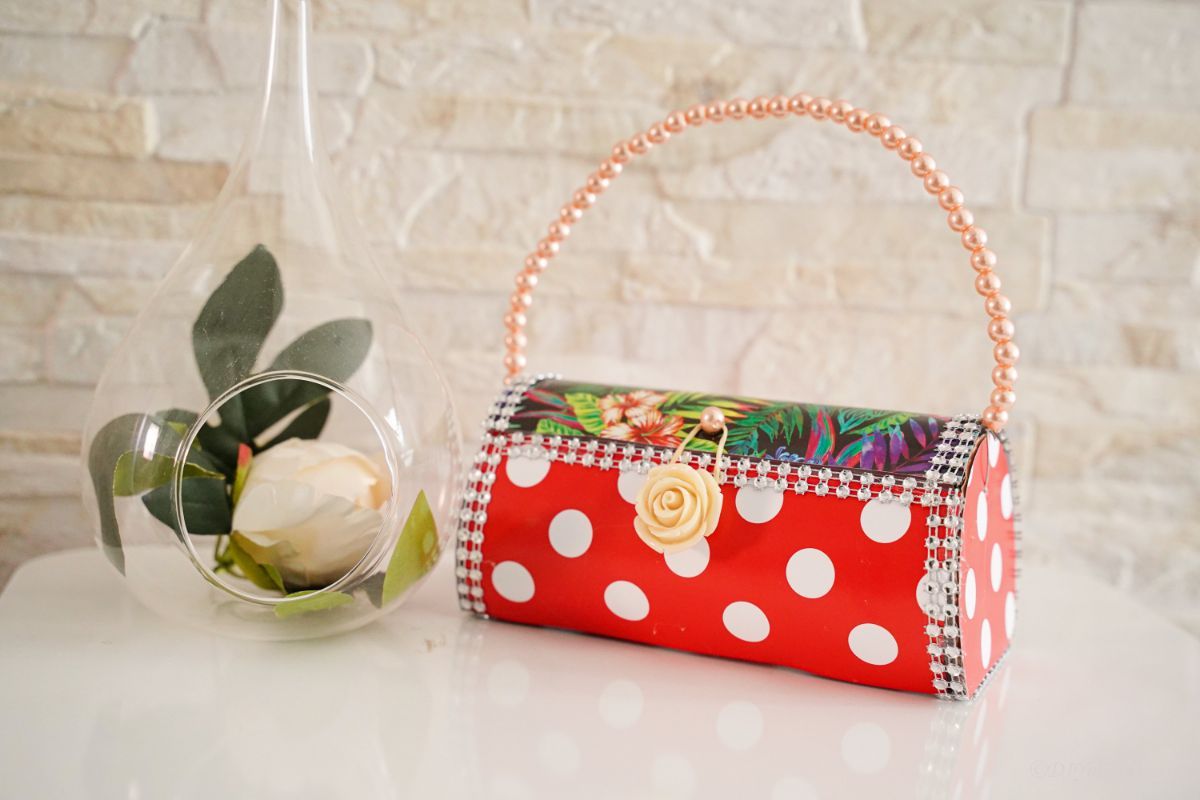 brick background behind small polka dot purse on white table