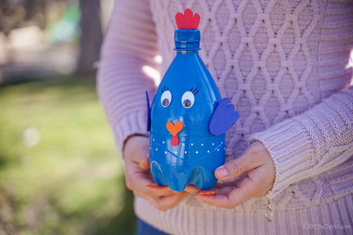 woman in pink holding blue bottle bird