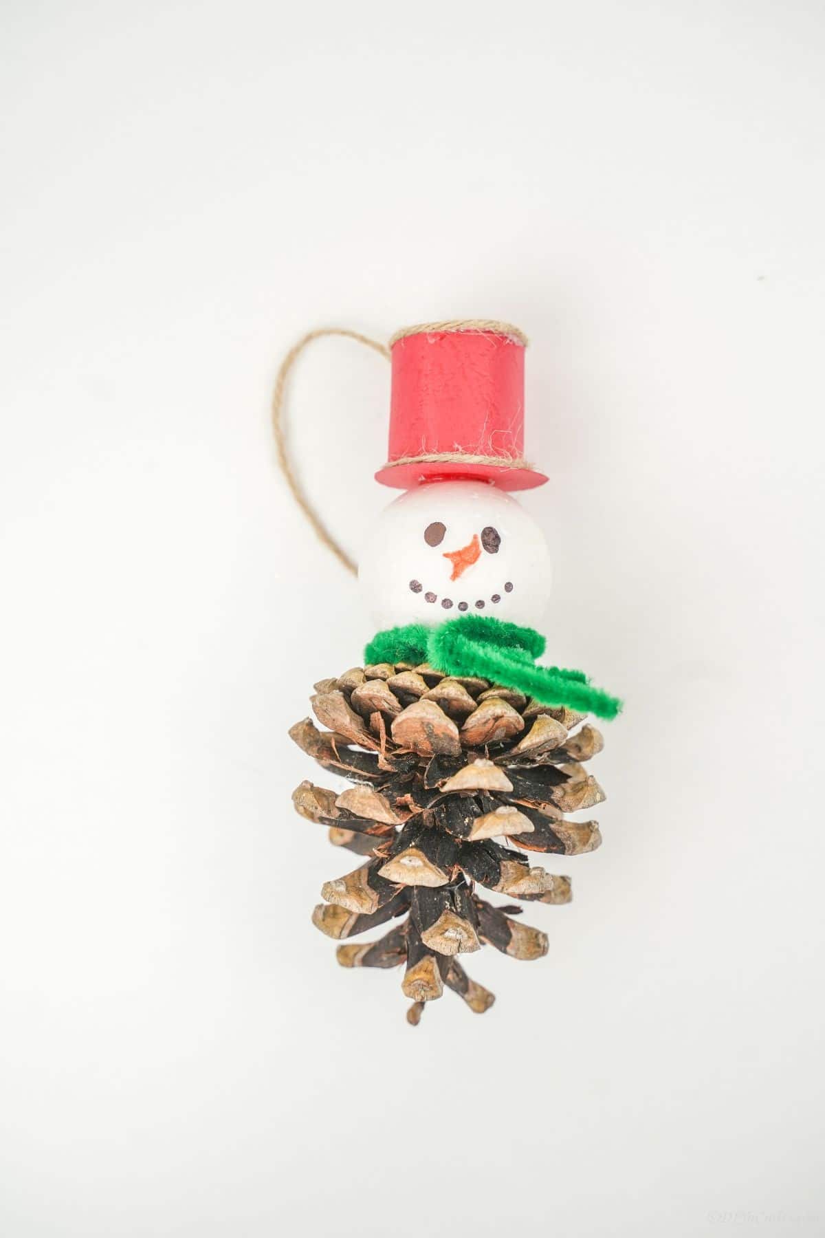pinecone snowman ornament on white table