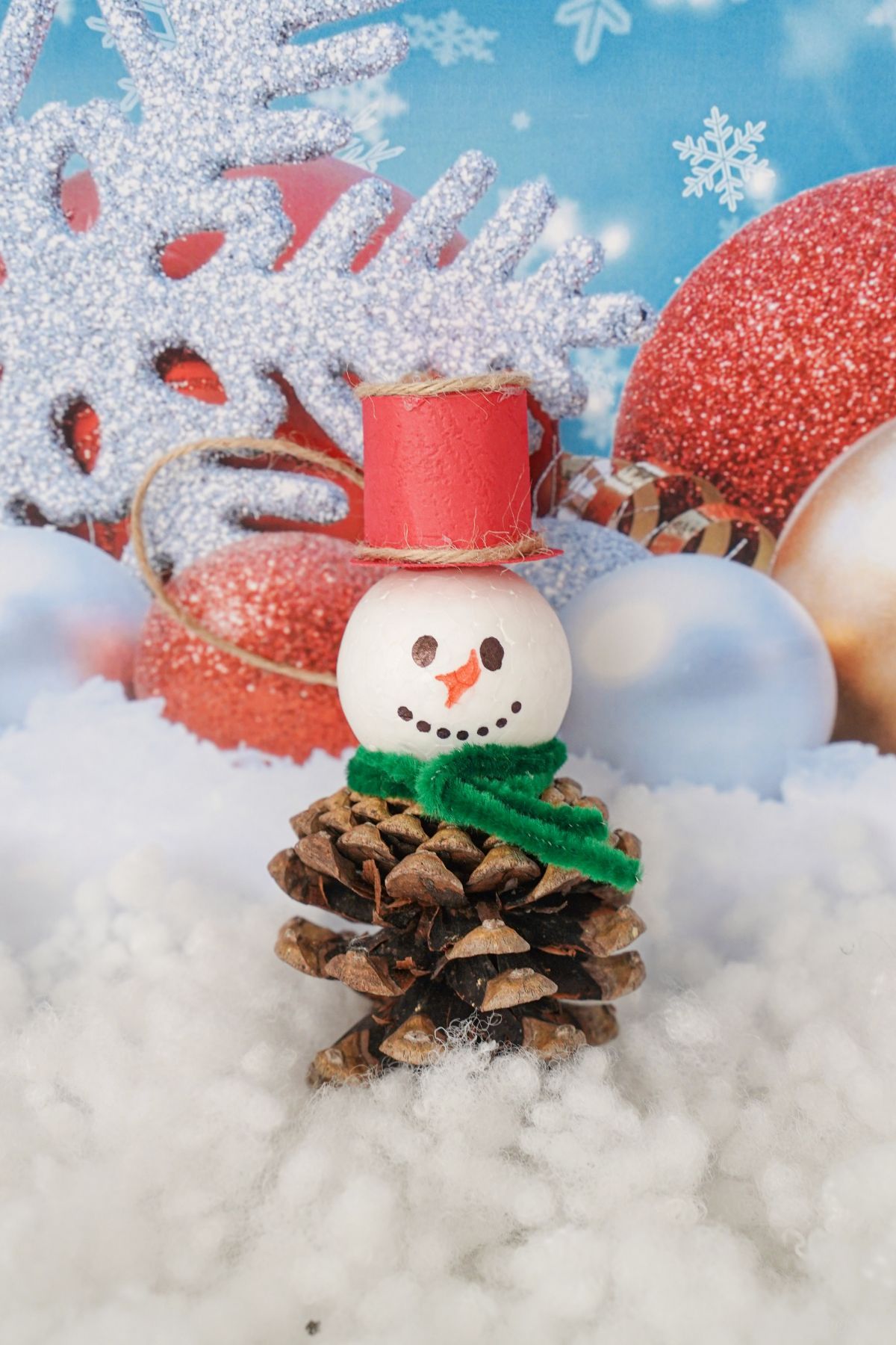 pinecone ornament in front of winter themed paper background