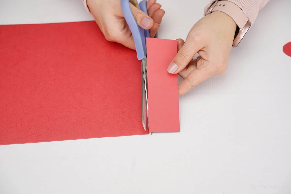 blue scissors cutting red paper