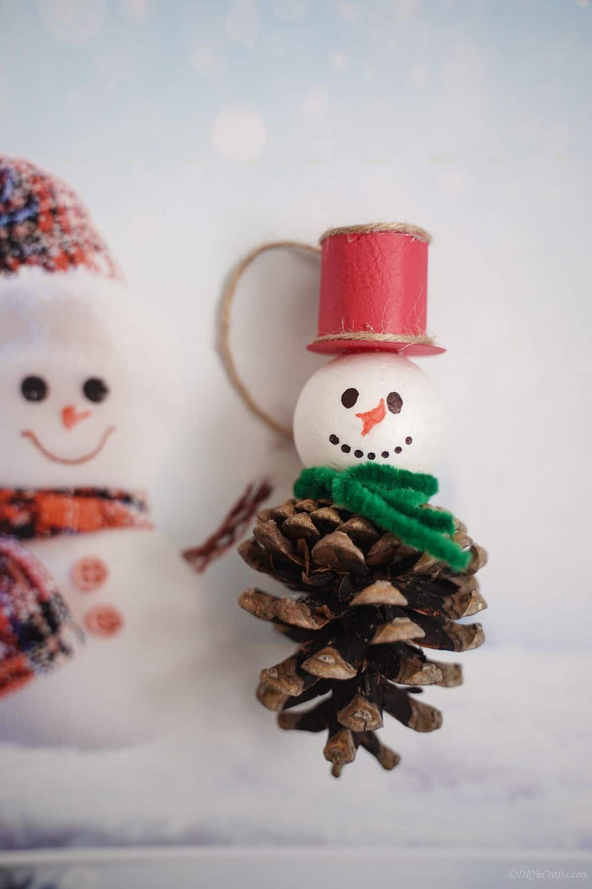 pinecone snowman on paper with fake snowman