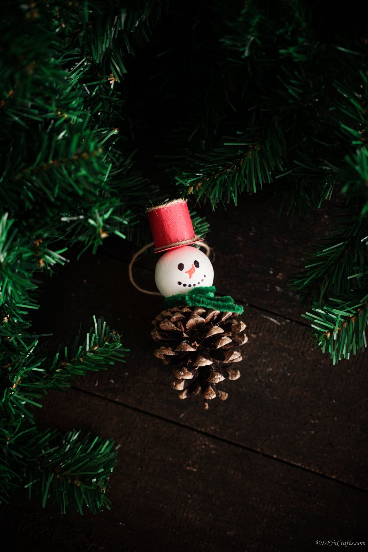 pinecone snowman laying on black table