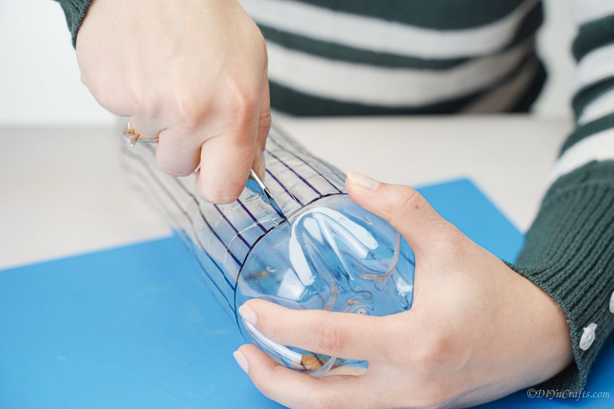 craft knife cutting through plastic bottle