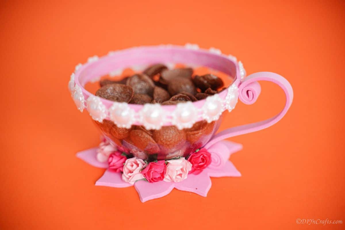 pink and white plastic teacup on orange paper