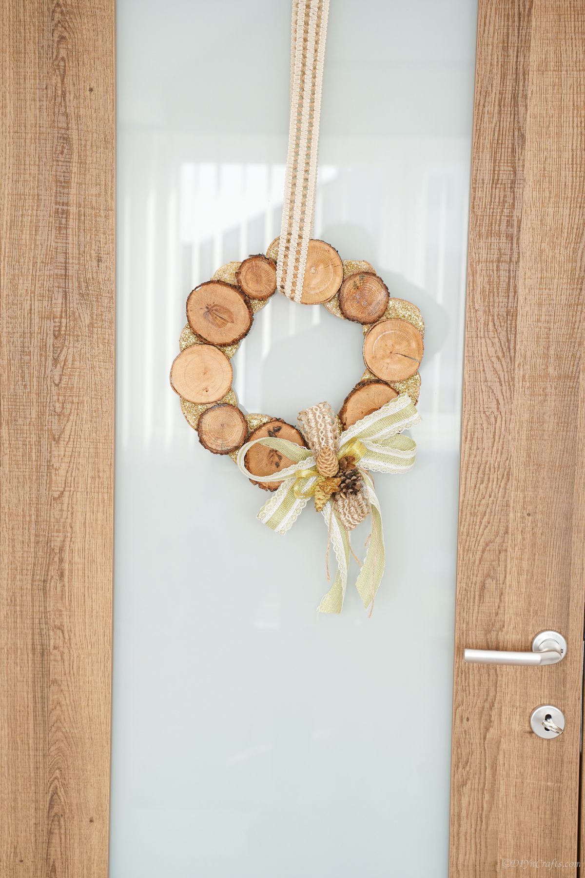 wood slice wreath on glass door with wood sides