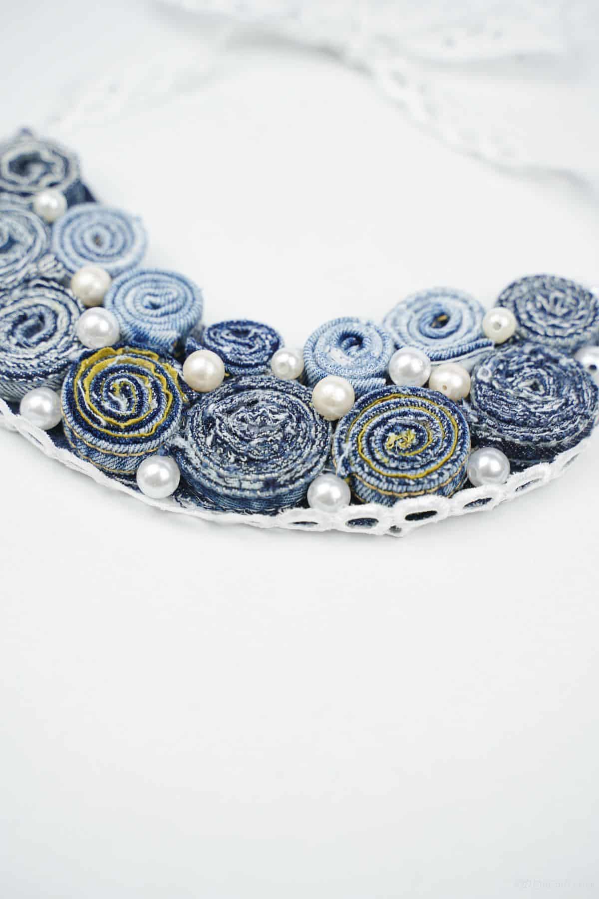 rolled denim necklace on white table
