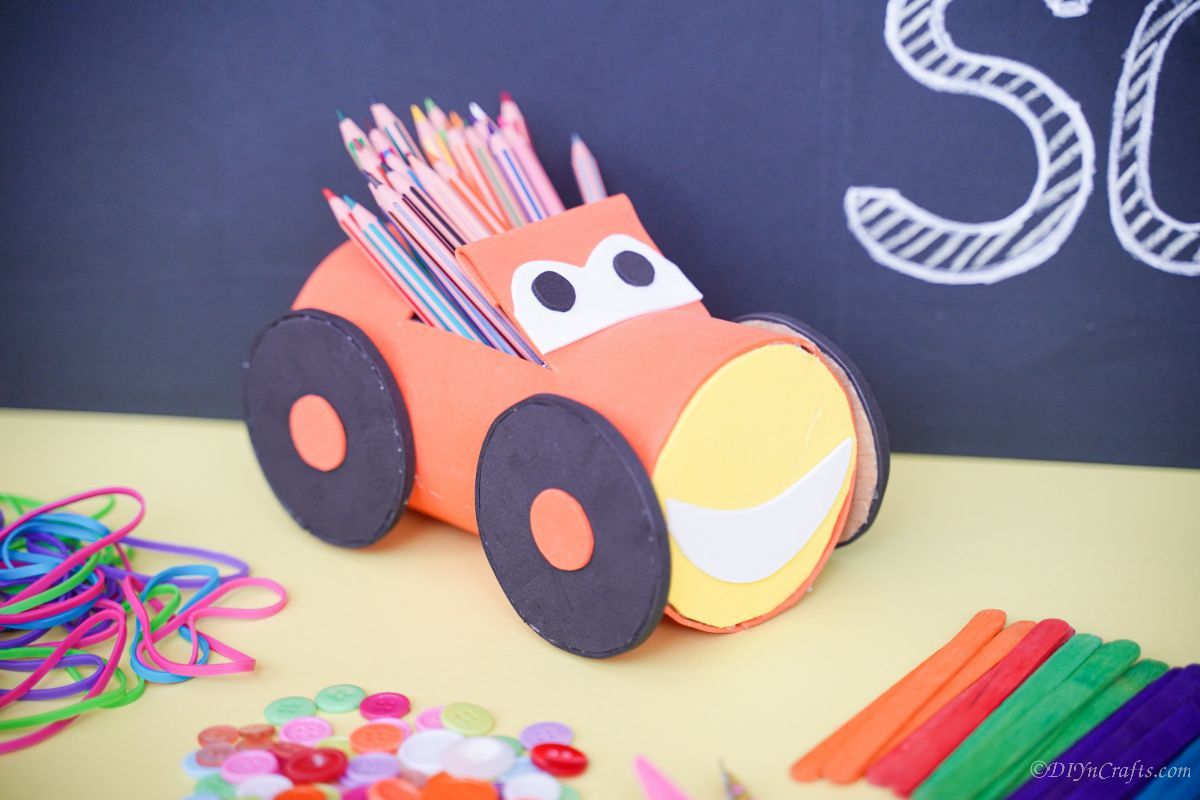 car pencil holder on yellow paper by chalkboard