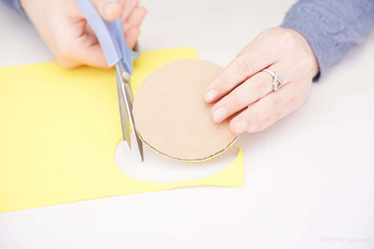 trimming yellow paper off cardboard circle