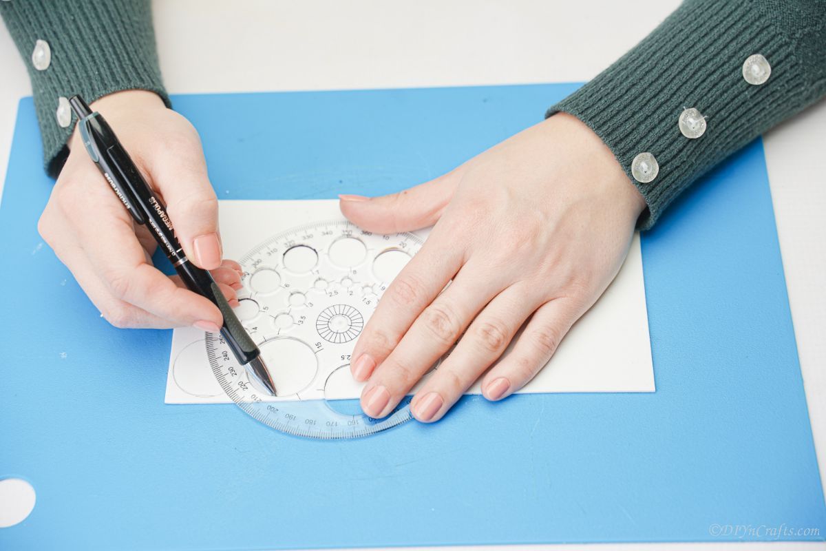 hand tracing circles on white paper