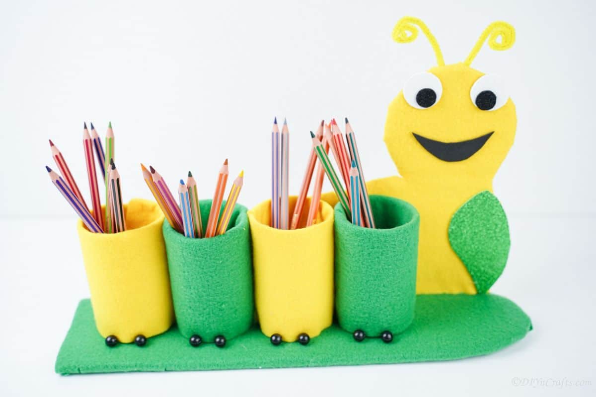 green and yellow pencil holder in front of white background