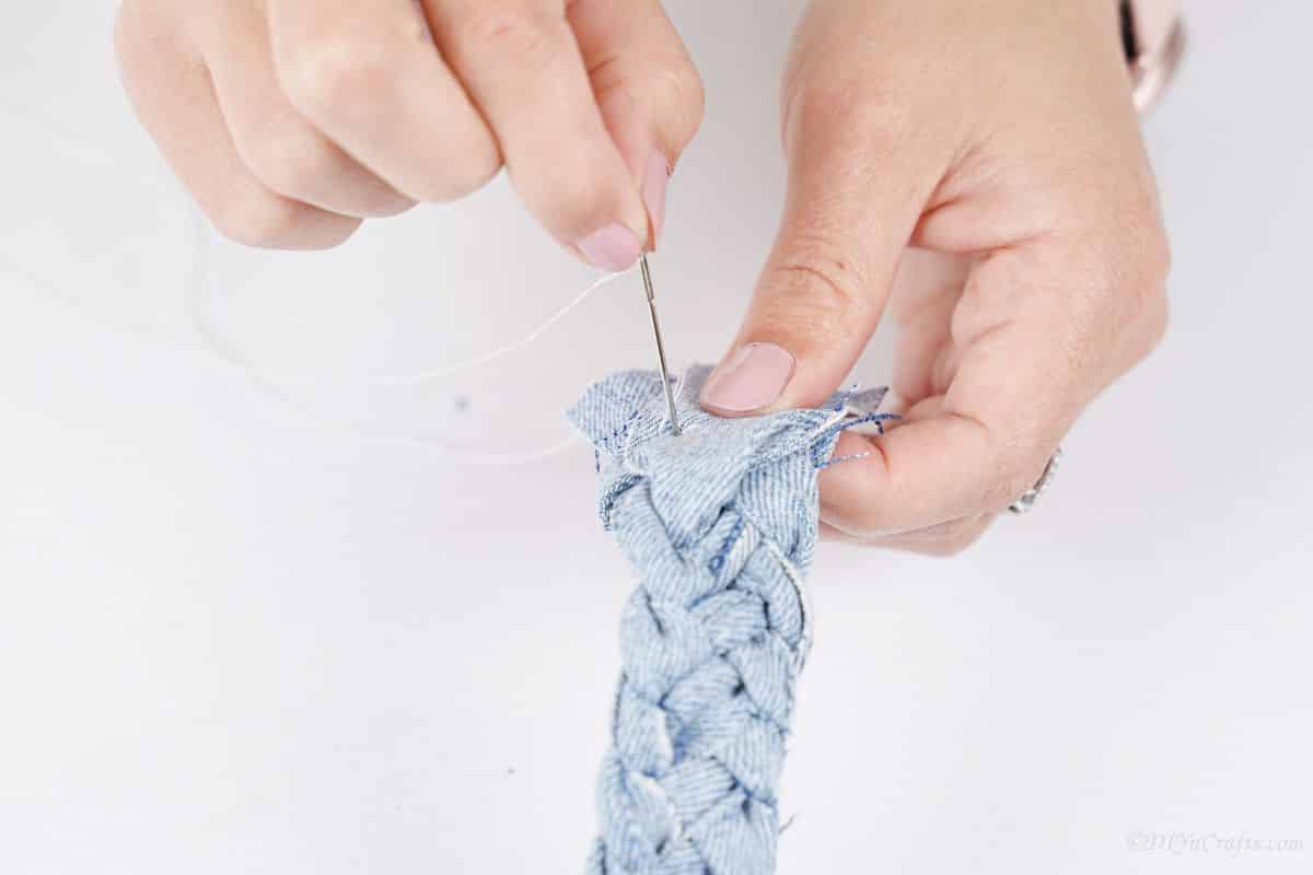 hand sewing the end of the denim braid