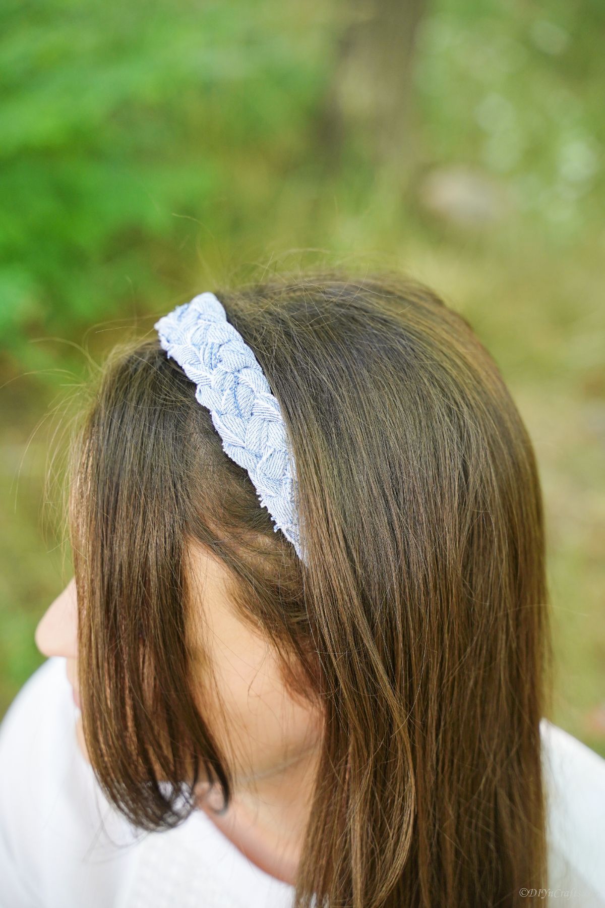 braided light wash denim headband being worn by woman in white shirt