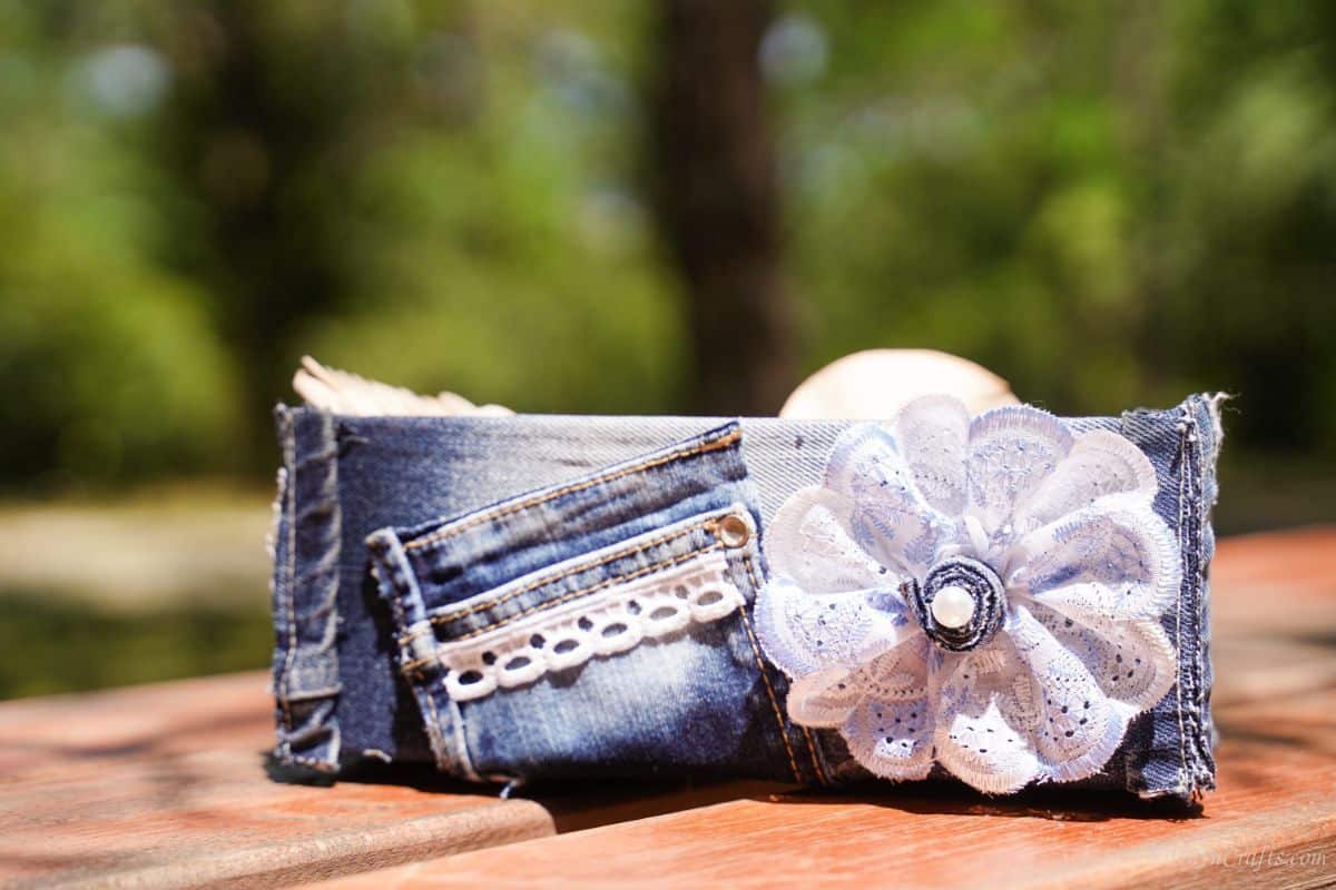 round lace bow on end of denim box that is sitting on a picnic table