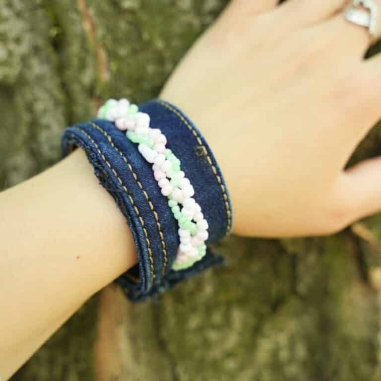 blue jeans beaded bracelet on arm touching tree