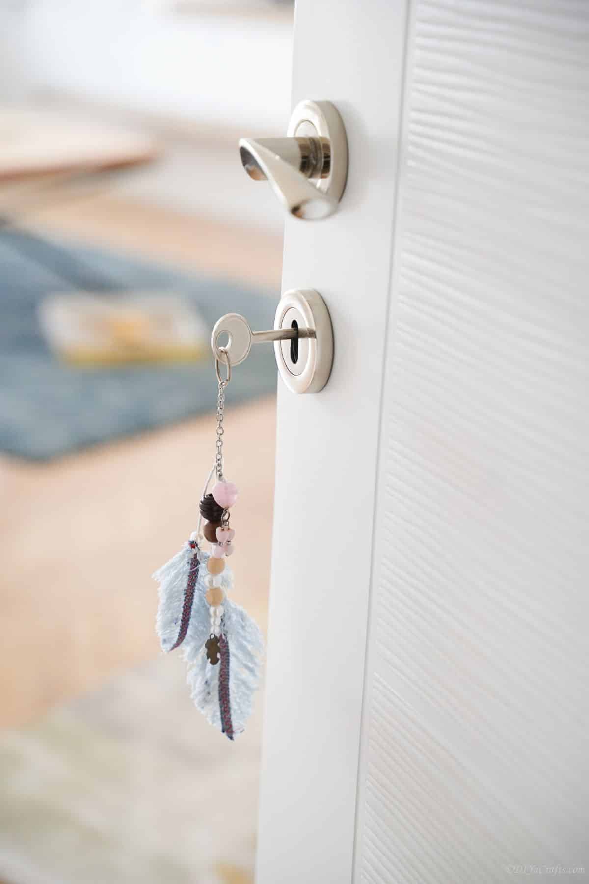 open white door with feather keychain hanging