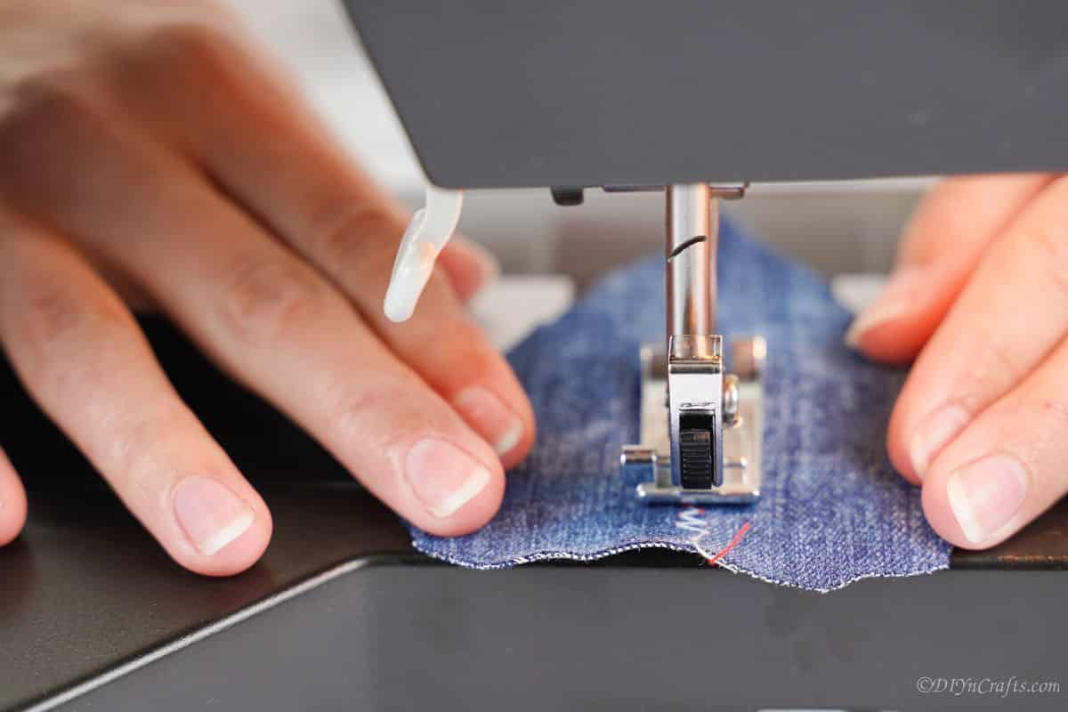 sewing a seam in the middle of a piece of denim using the sewing machine