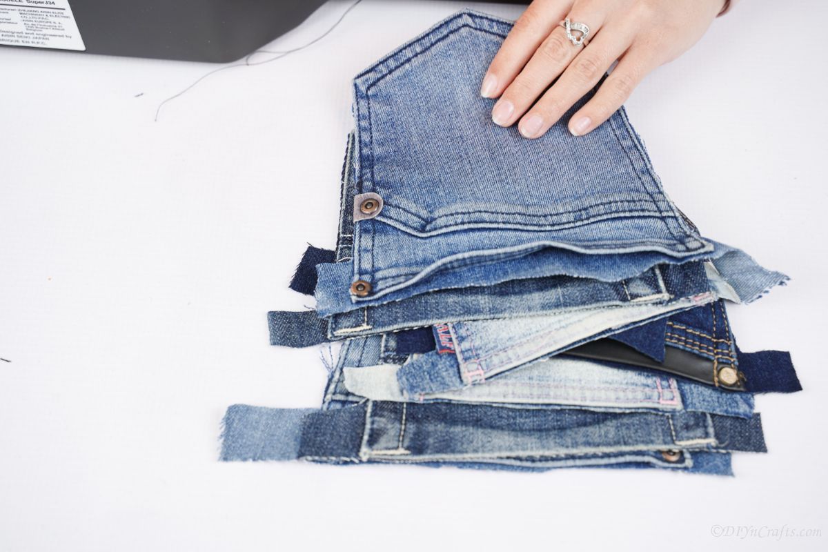 stack of pockets from blue jeans on white table