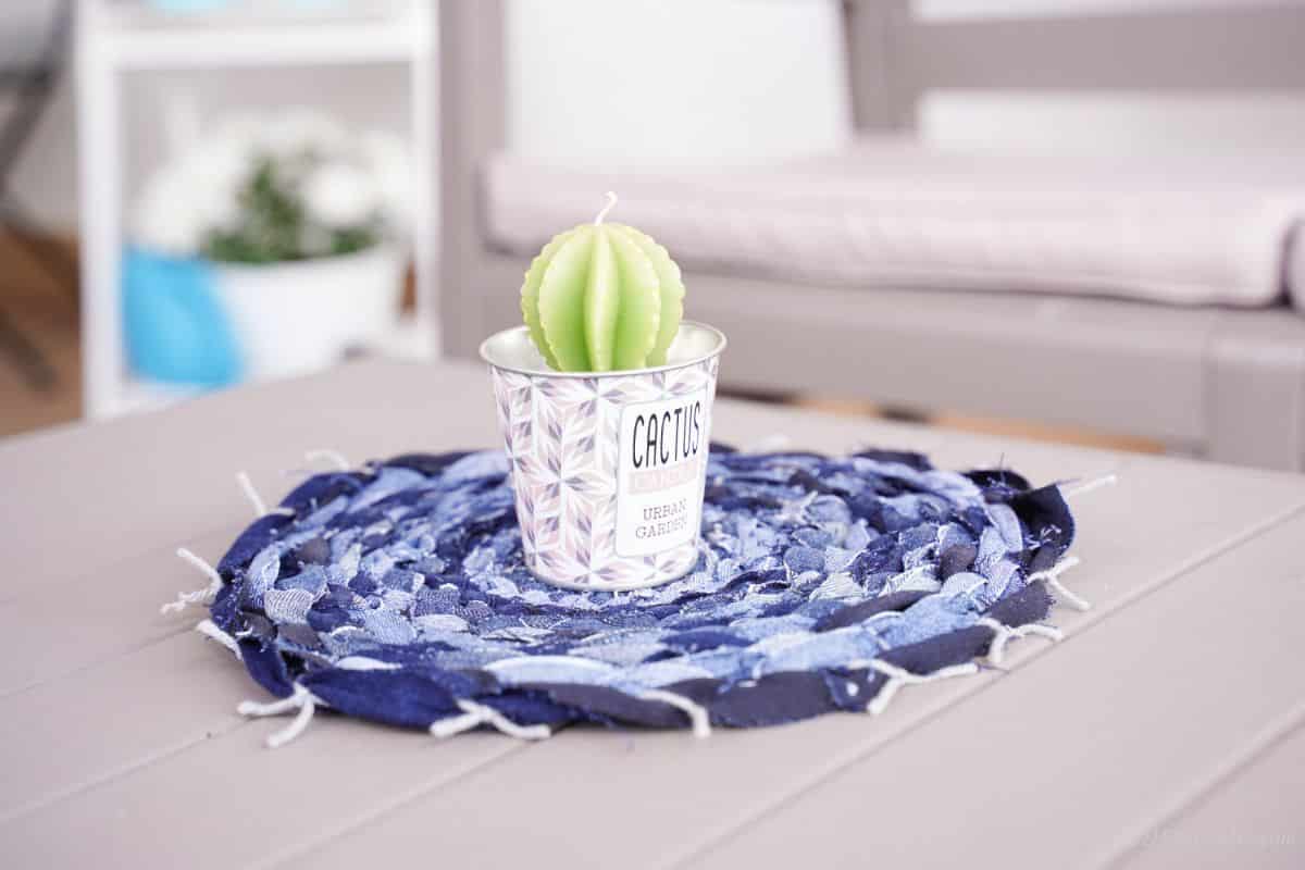 old blue jeans round placemat on gray table with catcus potted plant in center