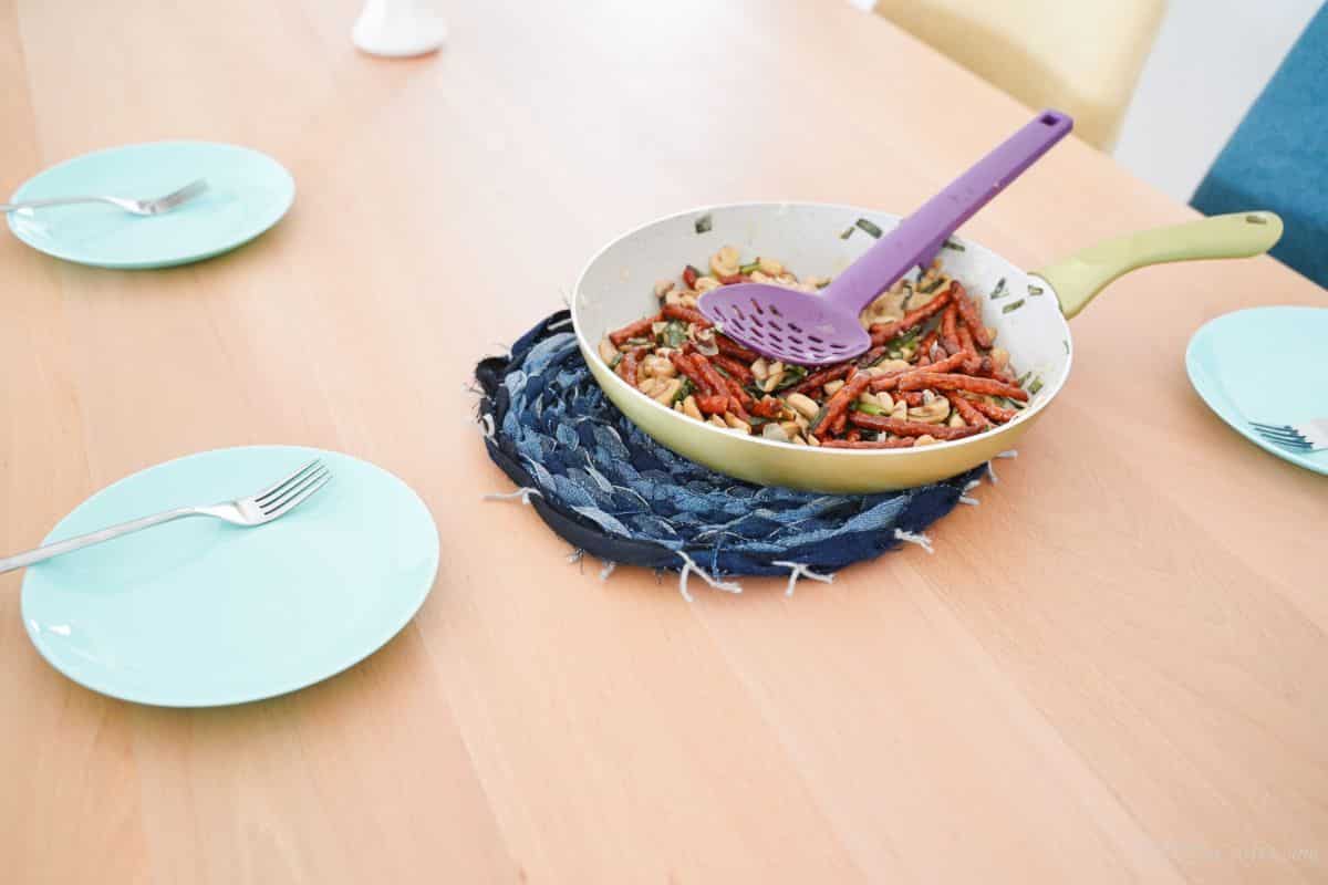 skillet of pasta on top of denim placemat on table