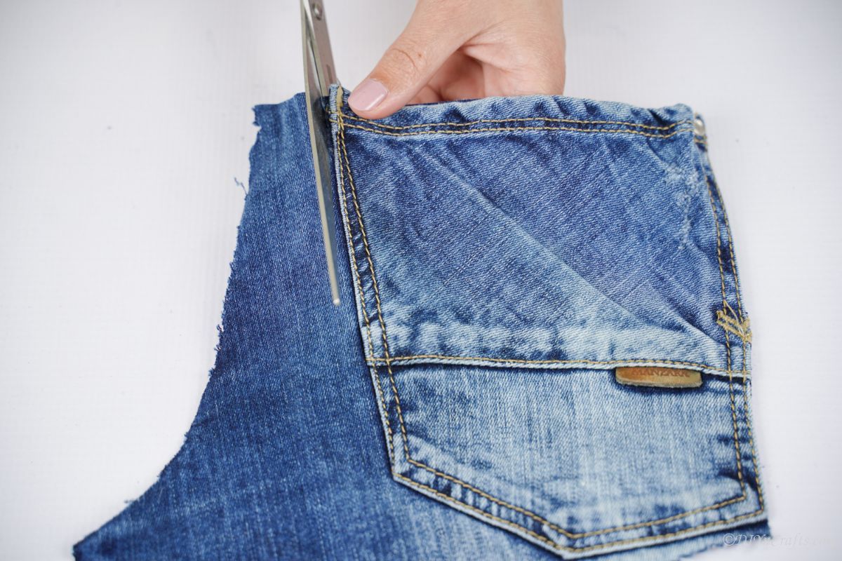 scissors cutting a pocket out of denim pants