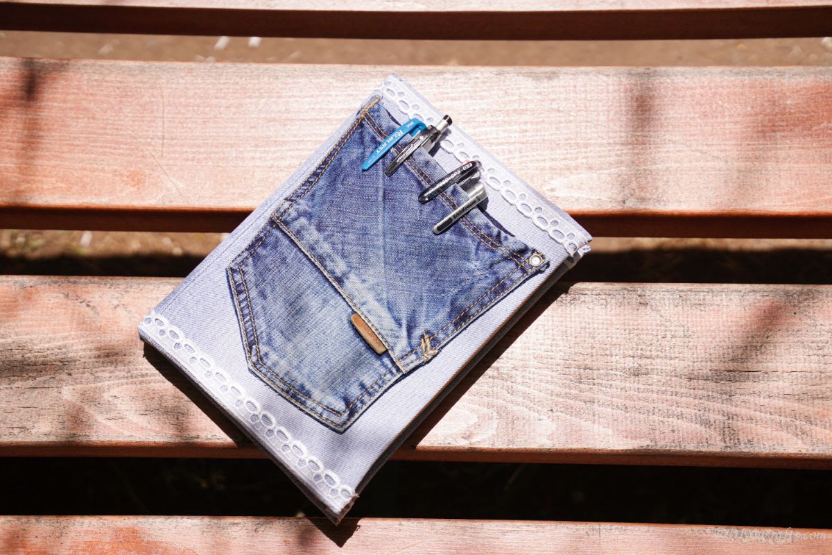 denim pocket on the front of a book laying on a picnic table