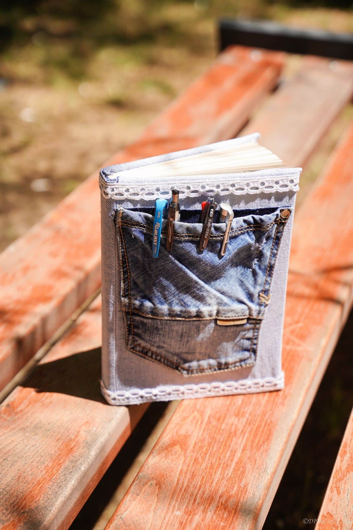 denim covered journal on wooden picnic table