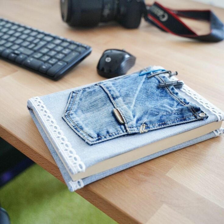 denim pocket on front of book laying next to keyboard and mouse on desk