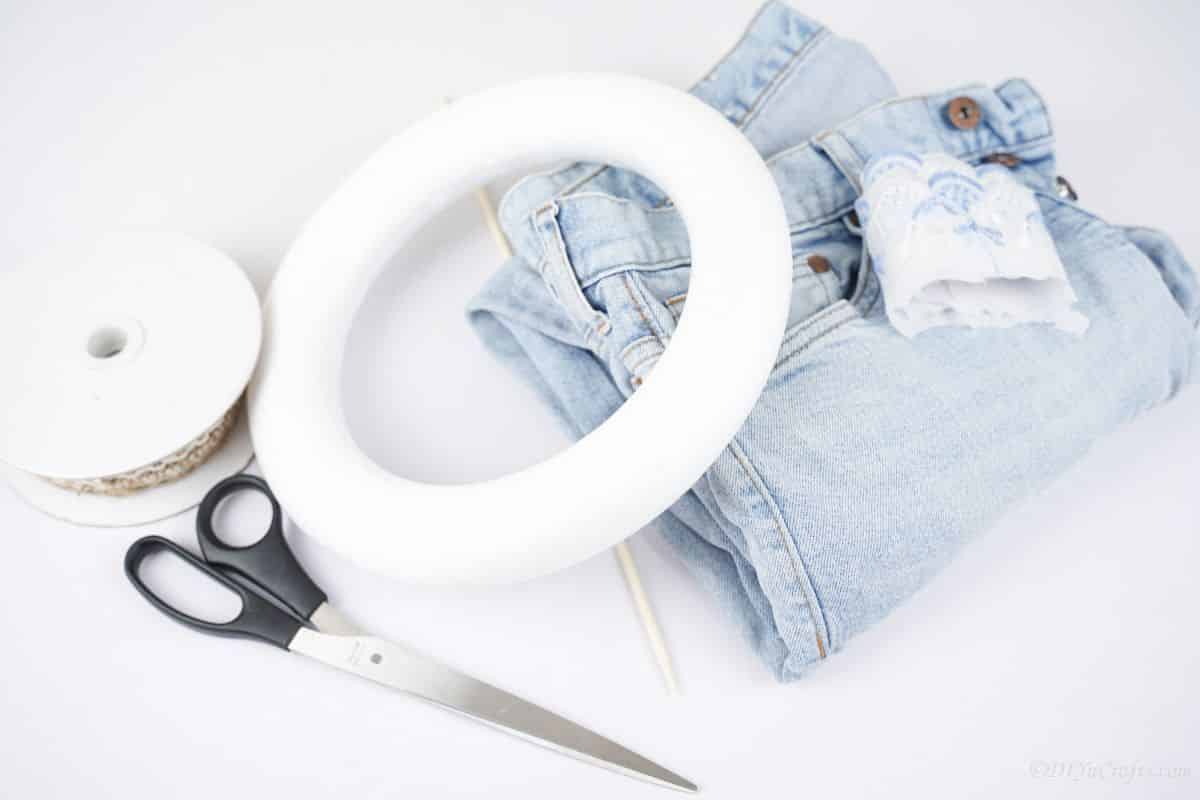 light blue denim on table with wreath form and scissors