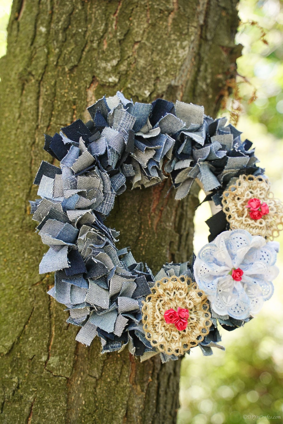 wreath made of old blue jeans hanging on tree